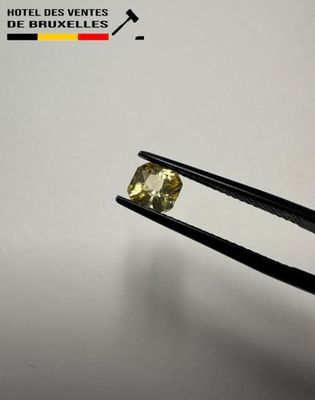 a close up of a pair of tongs holding a yellow diamond