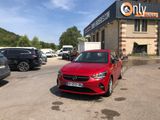 a red car parked in front of a building in a parking lot