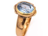 une image d'une bague en or avec une pierre en topaze bleue