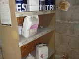 several cans of paint on a shelf in a room