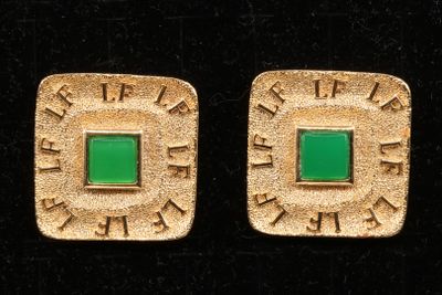pair of gold and green square earrings on black velvet