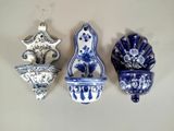 trois vases bleus et blancs accrochés au mur