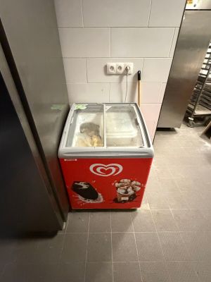 a small ice cream machine in a kitchen with a door open