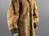 un mannequin vêtu d'un manteau de fourrure marron et de gants