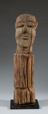 sculpture en bois représentant le visage d'un homme, posée sur un socle en bois