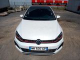 the white volkswagen golf gt is parked in front of a building