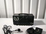 a black amplifier sitting on top of a table next to a charger