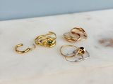 three gold and silver rings sitting on top of a marble counter top