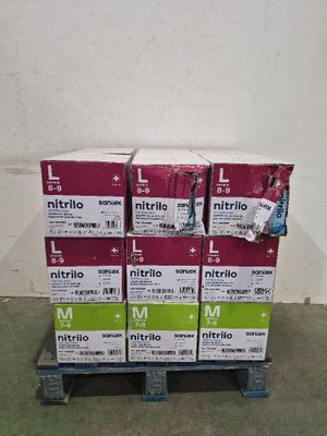 des cartons empilés sur une palette dans une pièce aux murs blancs