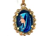 une image représentant un pendentif sur lequel figure une femme portant un voile bleu