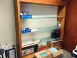 a room with a desk, shelves, and a printer in it