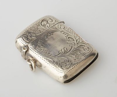 a silver cigarette case sitting on a white surface