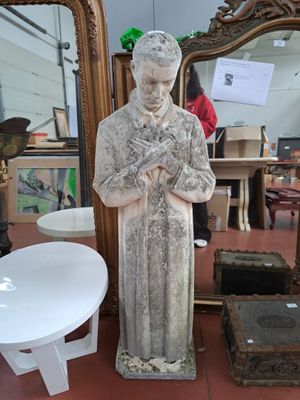 une statue représentant un homme debout devant un miroir