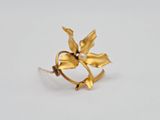 a close up of a gold ring with a flower on it