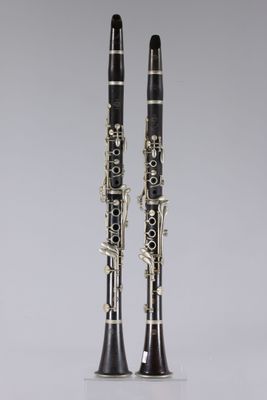 une paire de clarinettes posées sur une surface blanche
