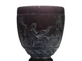 a black vase with a picture of a man in a boat on it
