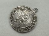 a close up of a silver coin on a white surface