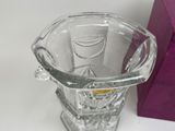 a glass vase that is sitting next to a purple box