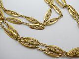 gros plan d'un collier en or sur une surface blanche