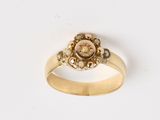 une image d'une bague en or avec une pierre rose au centre