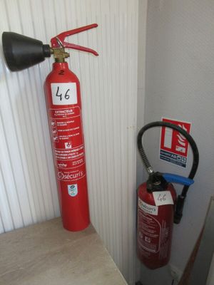 un extincteur à côté d'une lance à incendie
