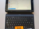 a tablet computer sitting on top of a laptop keyboard
