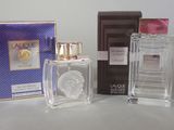 three bottles of perfume sitting next to each other on a table