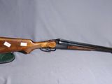 un fusil avec une crosse en bois et un chapeau vert sur fond blanc