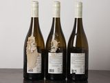 three bottles of wine sitting on a table next to each other