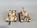 two toy tanks sitting next to each other on the floor
