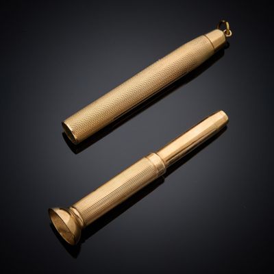 un stylo doré et un briquet sur fond noir