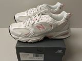 Les chaussures New Balance sont dans la boîte posée sur la table.