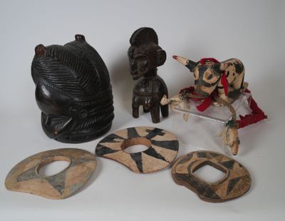 Plusieurs œuvres d'art africain sont exposées sur un fond blanc