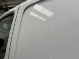 a white van parked in a garage with its door open
