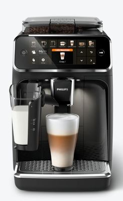 the coffee machine has a glass of milk in front of it