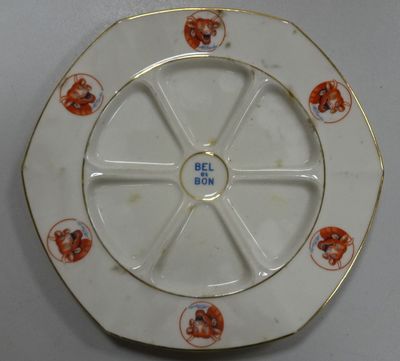 a white plate with a gold rim with a picture of a dog on it