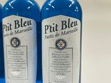 three bottles of blue wine are lined up on a table