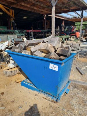 une benne bleue remplie de bois dans une cour