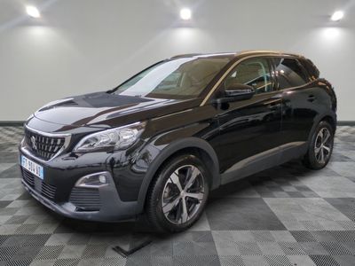 une voiture noire garée dans un garage au sol en damier