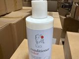une bouteille d'après-shampoing posée sur une boîte en carton