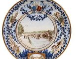 une image représentant une assiette bleue et blanche ornée d'un château