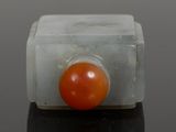 an orange ball sitting on top of a piece of marble