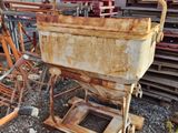 une machine rouillée posée par terre à côté d'un tas de ferraille