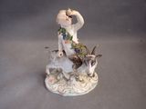 a figurine of a woman sitting on a goat