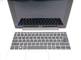 a white laptop with a black keyboard on a white table