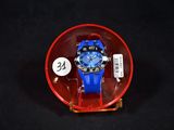 une montre bleue dans un écrin rouge posé sur une surface noire