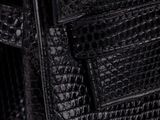 a close up of a black purse on a white background