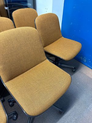 Dans une pièce, plusieurs chaises sont alignées contre un mur bleu