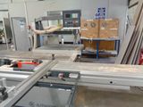 a machine that is cutting wood in a factory
