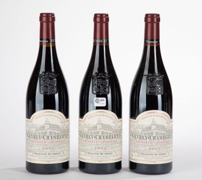 trois bouteilles de vin rouge posées sur une table blanche